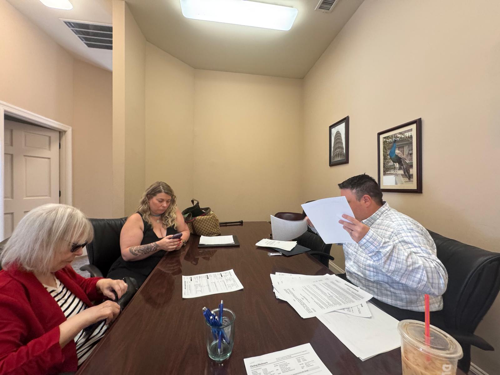 Closing table documents at attorney office — Alvear Group